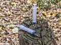 Two used syringes with blood inside, on a stump in the forest Royalty Free Stock Photo