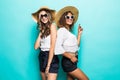 Two vacation girls with different color of skin wearing straw hats and summer clothing, sunglasses rejoicing their holiday Royalty Free Stock Photo