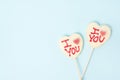 two Valentine\'s day heart shape candies with white chocolate on pastel blue paper background. Love Concept Royalty Free Stock Photo