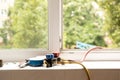 A two-valve manometric manifold lies on the windowsill in the apartment and measures the pressure in the air conditioner