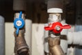 Two valves on plastic and metal pipes with hot and cold water. Open blue and closed red switches. Hot water is turned off Royalty Free Stock Photo