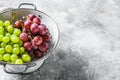Two varieties of grapes, red and green in a colander. Gray background. Top view. Copy space Royalty Free Stock Photo