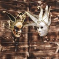 Two Venetian masks are stored on a wooden wall. Celebration and masquerade. Royalty Free Stock Photo