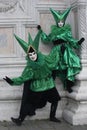 Two Venice Carnival costumes in green and black with Venice masks in February`s Venice Carnival Italy