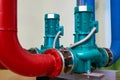 Two vertical engines painted blue with pumps connected to pipes painted red and blue. Royalty Free Stock Photo