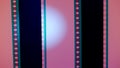 Two vertical film strips on a pink background with white circular light, close up. 35mm film slide frame. Long, retro Royalty Free Stock Photo