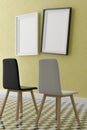 Two vertical white frame mock up, wooden frame and chairs on yellow wall, 3d illustration Royalty Free Stock Photo