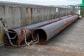 Two very large rusty pipes chained to a wall. Construction work and heavy engineering Royalty Free Stock Photo