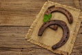 Two very old cast iron metal horse horseshoes, fresh clover leaf. Good luck symbol, St.Patrick`s Day concept Royalty Free Stock Photo