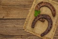 Two very old cast iron metal horse horseshoes, fresh clover leaf. Good luck symbol, St.Patrick`s Day concept Royalty Free Stock Photo