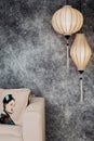 Vietnamese or Chinese white lanterns, spheric and oval, over vintage grunge concrete background with sofa and Vietnamese vintage