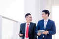 Two Vietnamese male coworkers talking and smiling