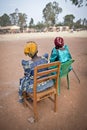 Two village ladies watch a football match at a school in Uganda