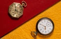 Two of vintage American and Swiss pocket watches with markings, lying on a books with red and yellow cover. Round dials Royalty Free Stock Photo