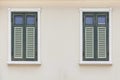 Vintage green shuttered wooden windows and cream colored facades