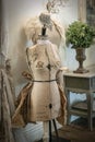 Two vintage mannequins sit in a shabby chic room