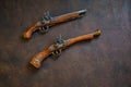 Two vintage duel pistols on wooden background Royalty Free Stock Photo