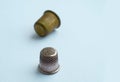 Two vintage thimbles stand in a row isolated on a colored background.