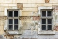 Two vintage windows in a white wooden frame on a grunge damaged wall. Royalty Free Stock Photo