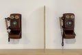 vintage wooden telephones hanging on a white wall