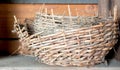 Two vintage woven baskets on a wooden shelf