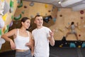 Girl gym coach and teen client standing in fitness room discussing possible options climbing Royalty Free Stock Photo