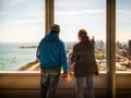 Two visitors looking out of a skyscraper window at Lake Michigan Royalty Free Stock Photo