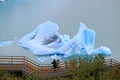 Two Visitors at the Viewing Balcony in front of the Huge Iceberg on Lake Agentino, Los Glaciares National Park, Argentina