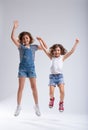 Two vivacious lively little girls jumping together Royalty Free Stock Photo