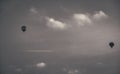 two hot air balloons flying through the cloudy sky, in an attempt to be a Royalty Free Stock Photo