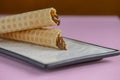 Two waffle cones with sweet boiled condensed milk in white plate on pastel pink background. Condensed tubules. Royalty Free Stock Photo
