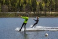Two wakeboarder ride a wakeboard on the lake. Wakeboarding is cool, extreme sport