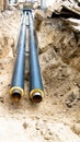 Water pipes in ground pit trench ditch during plumbing under construction repairing Royalty Free Stock Photo