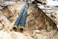Water pipes in ground pit trench ditch during plumbing under construction repairing Royalty Free Stock Photo