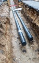 Two water pipes in ground pit trench ditch during plumbing under construction repairing Royalty Free Stock Photo