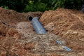 An old steel water pipe with a welded flange lies next to a new plastic pipe installed to connect the water Royalty Free Stock Photo