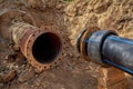 An old steel water pipe with a welded flange lies next to a new plastic pipe installed to connect the water supply system Royalty Free Stock Photo