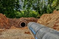 An old steel water pipe with a welded flange lies next to a new plastic pipe installed to connect the water supply Royalty Free Stock Photo