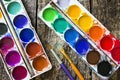 Two watercolor paints and different brushes for drawing on an old wooden Royalty Free Stock Photo