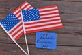 Two wave flags of the United States on woodek desk.