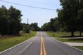 Two-way road divided by two yellow solid lines. two lane road. road with trees on both sides, through the Florida forest