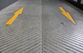 Two way Yellow Arrow signs as road markings. Arrow sign on slope floor at park building Royalty Free Stock Photo