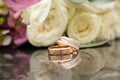 two wedding gold rings on a dark mirror background carried a bouquet of flowers, wedding gold rings Royalty Free Stock Photo