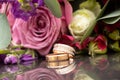 two wedding gold rings on a dark mirror background carried a bouquet of flowers, wedding gold rings Royalty Free Stock Photo