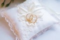 Two wedding gold rings lying on silk lace cushion Royalty Free Stock Photo