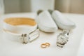 Two wedding rings with accessories for the groom. Wrist watch, leather belt and shoes on a white background.