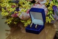 Two wedding rings are in a blue crust on the table and the bride`s bouquet of pink peonies. Royalty Free Stock Photo