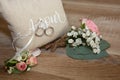 Two wedding rings on brown natural pillow with ribbon and amour text means love in french with bride groom flowers decoration