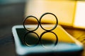 Two wedding rings in the form of number eight stand on a white phone on the table. The rays of the sun pass through the Royalty Free Stock Photo