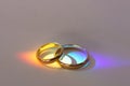 Two wedding rings with rainbow light